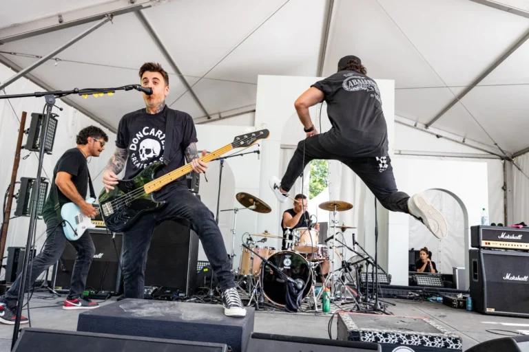 Band performing with singer mid-jump — Punchline 13, Vans Warped Tour Montreal 2026